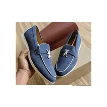 Chaussures Loro Piana en cuir beige posées sur fond bois