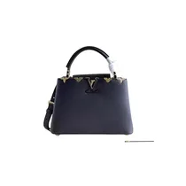 Vue de face du sac Louis Vuitton Capucines MINI en cuir noir