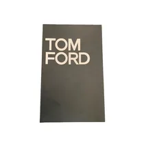 Gros plan sur le texte TOM FORD en lettres capitales blanches sur la tranche du livre décoratif