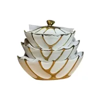 Gros plan sur les finitions dorées et la texture pétale de la porcelaine blanche.