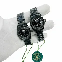 Détail du cadran noir et de la lunette crantée de la montre homme avec loupe de date.