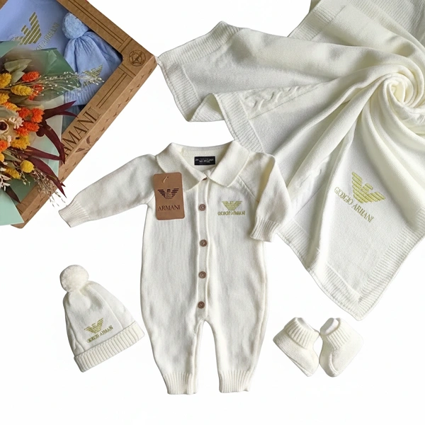 Coffret complet naissance Giovanni Armani couleur crème avec couverture et accessoires sur fond blanc.