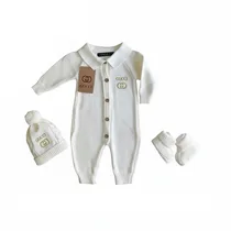 Détail du logo Gucci doré brodé sur bonnet naissance.