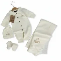 Ensemble complet Fendi pour bébé avec combinaison, bonnet, chaussons et couverture sur fond blanc.