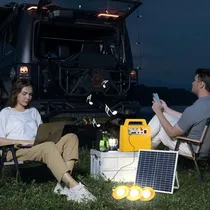 Générateur solaire en utilisation nocturne pour le camping près d'un véhicule.