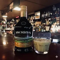 Verre de crème irlandaise Merrys servie sur des glaçons avec coulis de caramel.