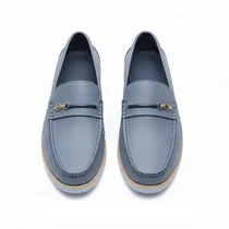 Détail empiècement métallique et cuir texturé chaussure homme.