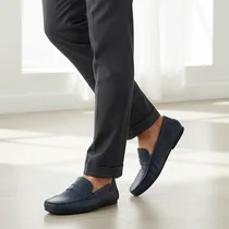 Paire de mocassins Calvin Klein portée avec pantalon élégant.