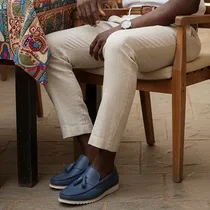 Paire de Mocassin Clarks Homme Pompons Bleu Cuir présentée sur sol urbain.