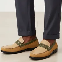 Gros plan des mocassins J.M. Weston portés avec un pantalon de costume gris.