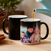 Mug magique noir posé sur une table de petit-déjeuner à côté d'une théière.