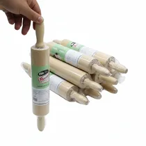 Main tenant un rouleau à pâtisserie en bois neuf sous emballage protecteur.