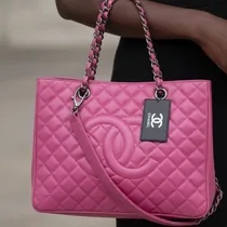 Sac porté à l'épaule sur une tenue élégante noire.