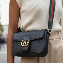 Femme portant sac Gucci noir bandoulière en cuir lisse.