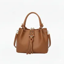 Gros plan du grand sac à main marron clair avec pompon.