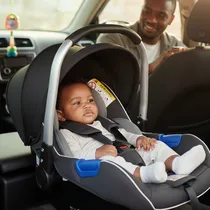 Bébé installé dans son siège auto sur la banquette d'un véhicule.