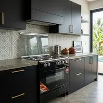 Cuisinière mixte ND 800BB noire et inox avec 4 foyers gaz et plaque électrique dans une cuisine