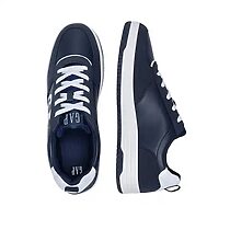 Homme portant les tennis GAP bleu marine avec un jean dans les rues de Douala.